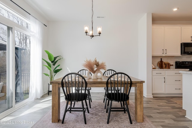 dining room with a chandelier, recessed lighting, light wood-type flooring, and a healthy amount of sunlight