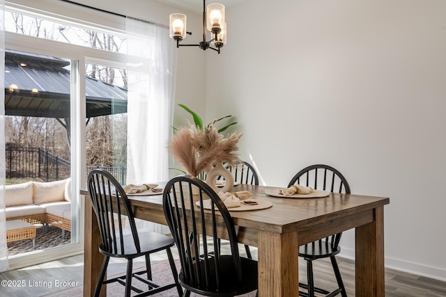 dining room featuring a notable chandelier, baseboards, and wood finished floors