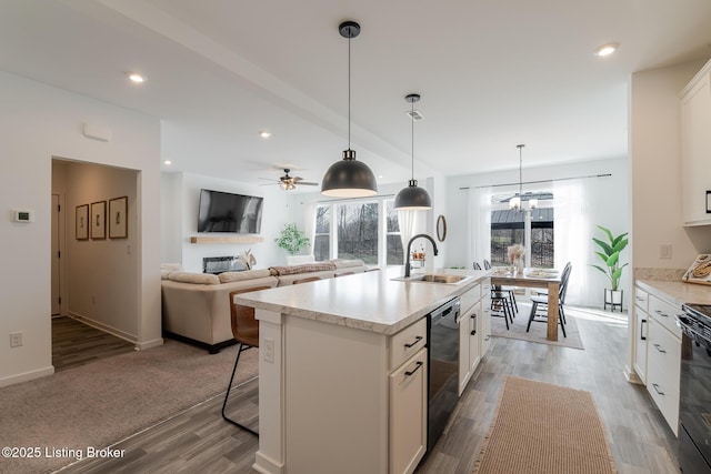 kitchen with recessed lighting, a sink, white cabinets, light countertops, and dishwasher