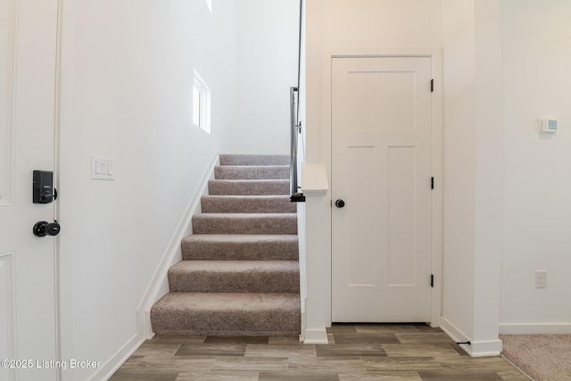 staircase with wood finished floors and baseboards