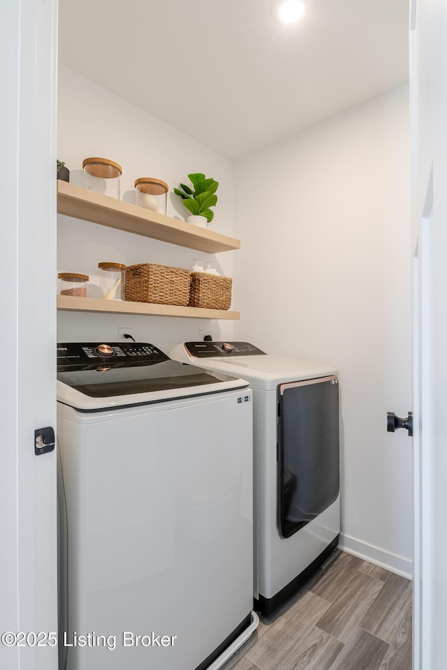 washroom with laundry area, washing machine and clothes dryer, and light wood-style floors