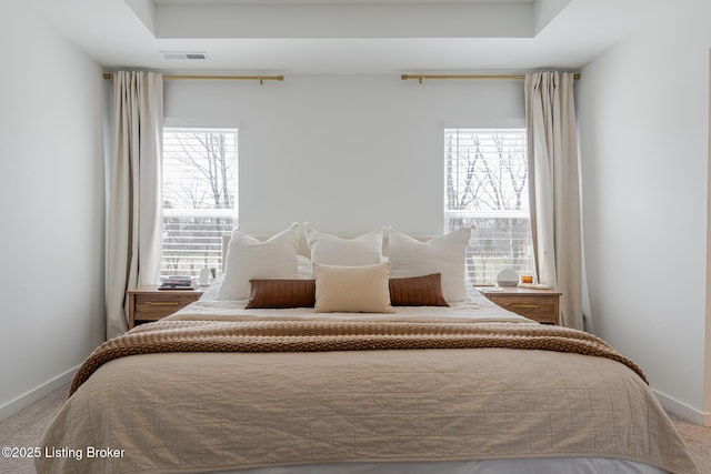 carpeted bedroom with baseboards, multiple windows, and visible vents