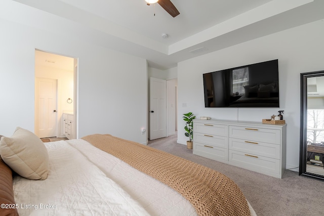 bedroom with a ceiling fan, light colored carpet, connected bathroom, and visible vents