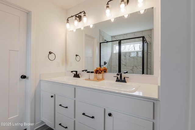 full bath with double vanity, a shower stall, and a sink