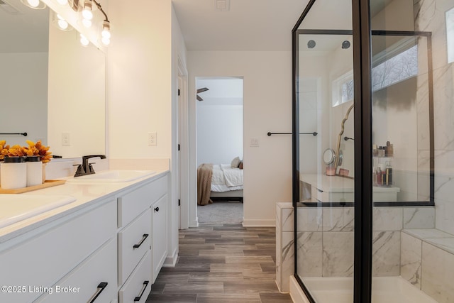 bathroom featuring ensuite bathroom, wood finished floors, a sink, double vanity, and a stall shower