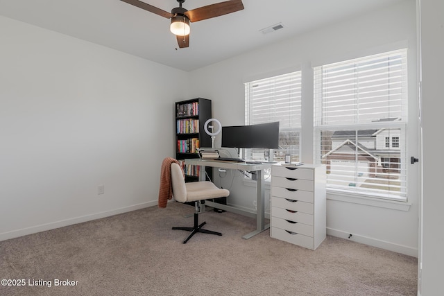 office space featuring light carpet, ceiling fan, visible vents, and baseboards