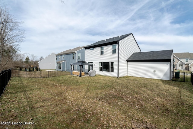 back of house featuring a residential view, a fenced backyard, a lawn, and a gazebo