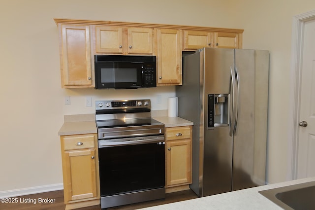 kitchen featuring light brown cabinets, stainless steel appliances, and light countertops