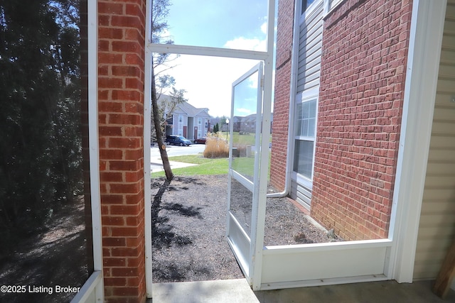 doorway featuring brick wall