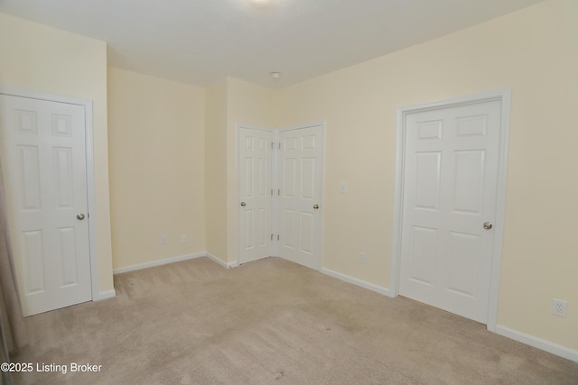 unfurnished bedroom with light carpet and baseboards