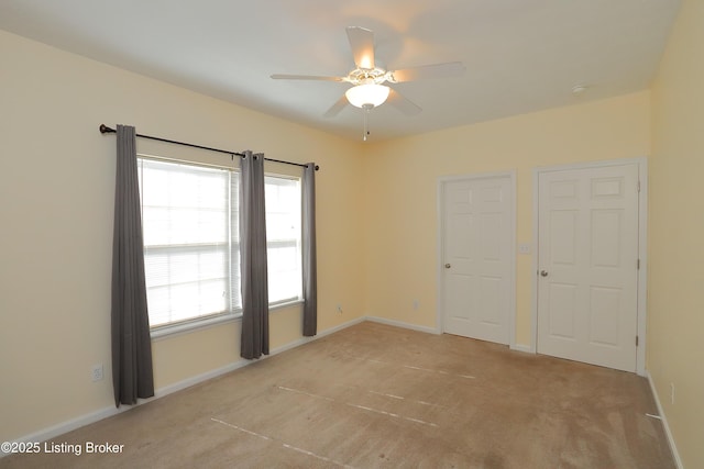 unfurnished bedroom featuring a ceiling fan, baseboards, and carpet flooring