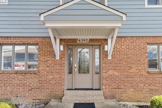 doorway to property with brick siding