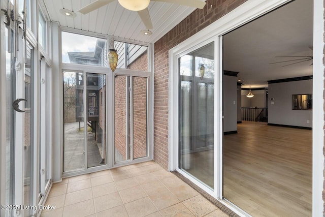 unfurnished sunroom with ceiling fan