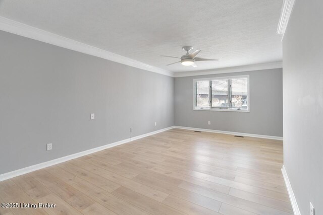 spare room with baseboards, a ceiling fan, light wood-style flooring, and crown molding