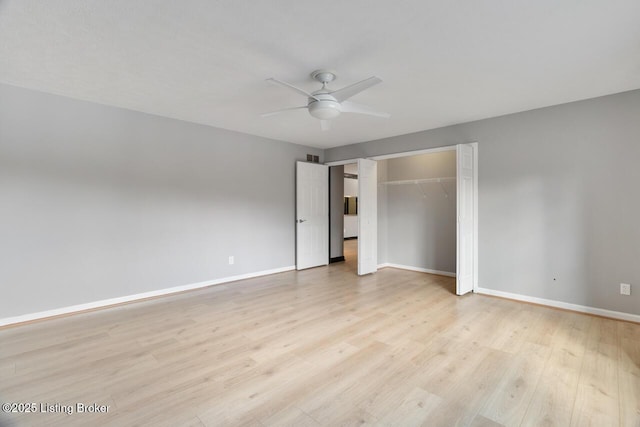 unfurnished bedroom featuring light wood-style floors, a ceiling fan, baseboards, and a closet