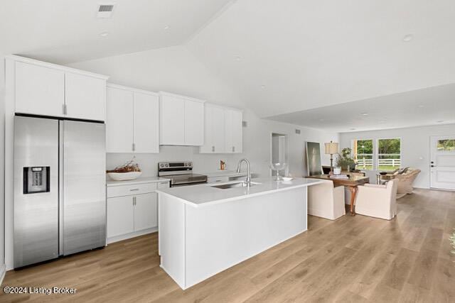 kitchen featuring appliances with stainless steel finishes, white cabinetry, and a sink