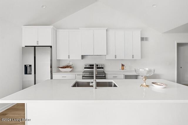 kitchen featuring stainless steel appliances, light countertops, visible vents, white cabinetry, and a sink