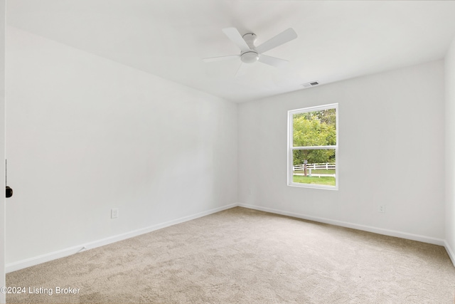 spare room featuring carpet floors, baseboards, visible vents, and a ceiling fan