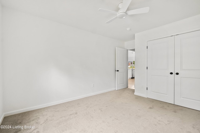 unfurnished bedroom with a closet, carpet, a ceiling fan, and baseboards