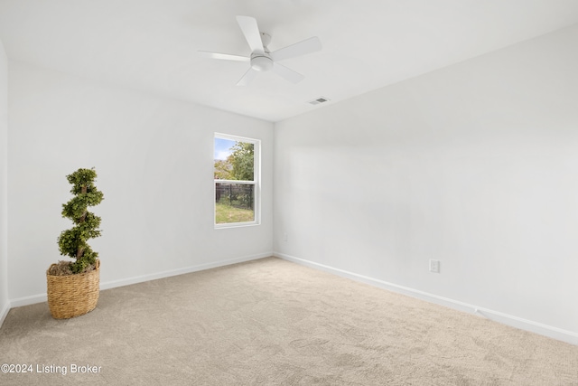 spare room featuring carpet floors, ceiling fan, and baseboards