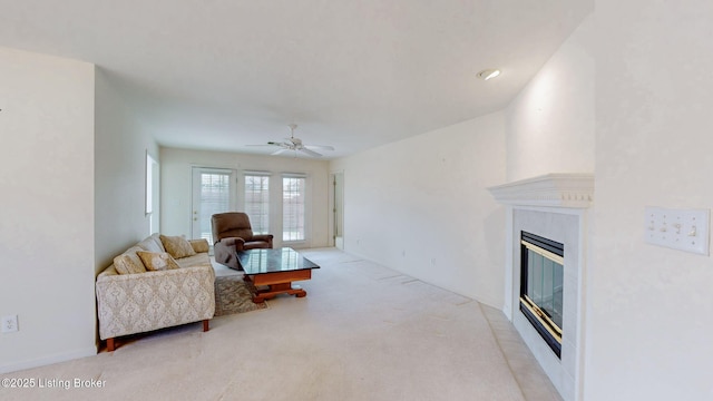 living room with light carpet, a glass covered fireplace, and ceiling fan