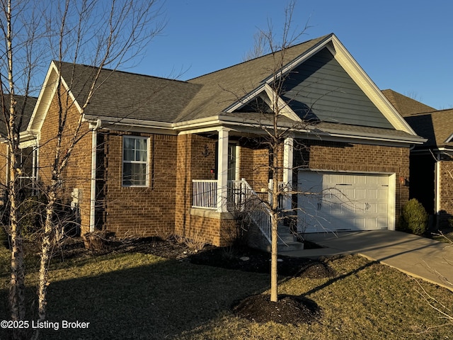 view of front of home featuring driveway, a garage, a shingled roof, covered porch, and brick siding