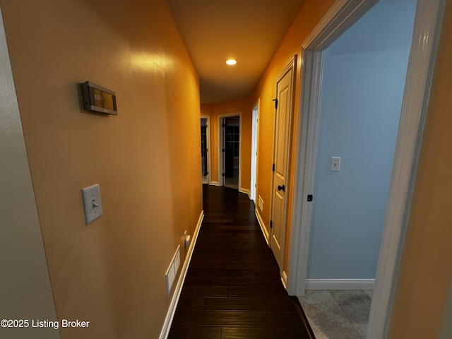 hallway with recessed lighting, wood finished floors, visible vents, and baseboards