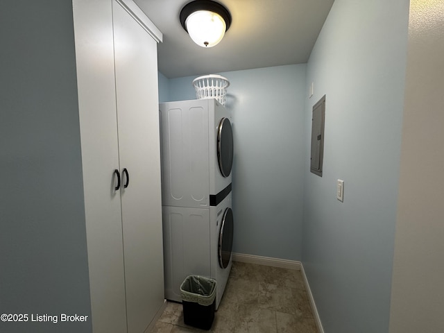 washroom featuring laundry area, stacked washer / dryer, electric panel, and baseboards