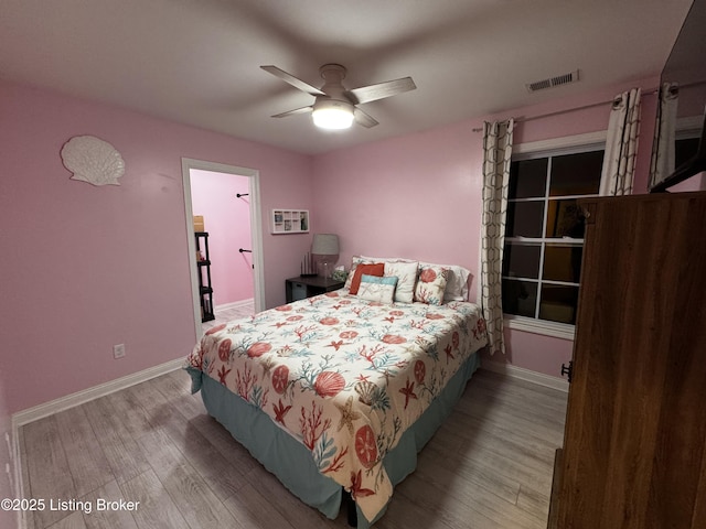 bedroom with visible vents, ceiling fan, baseboards, and wood finished floors