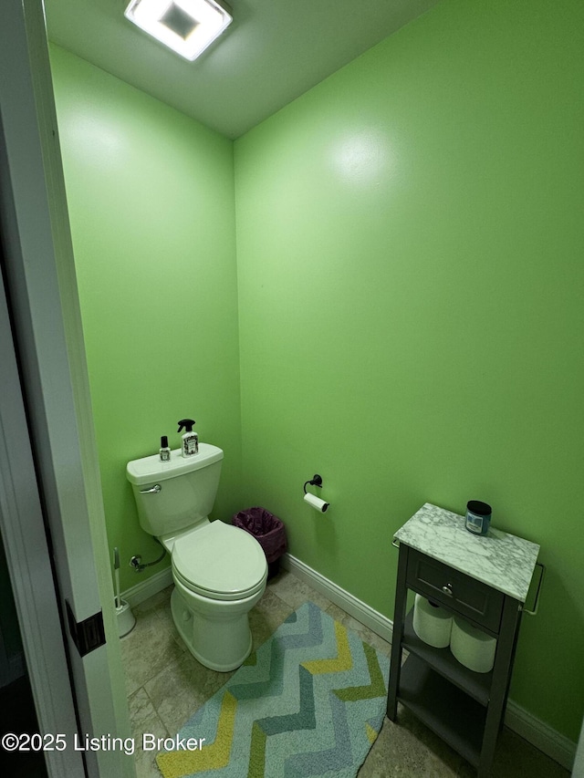 bathroom featuring baseboards and toilet