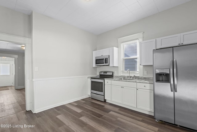 kitchen featuring white cabinetry, appliances with stainless steel finishes, dark wood-type flooring, and a sink