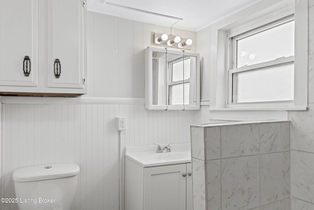 bathroom featuring wainscoting, vanity, and toilet