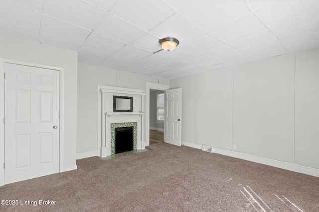 unfurnished living room with baseboards, carpet, visible vents, and a tiled fireplace