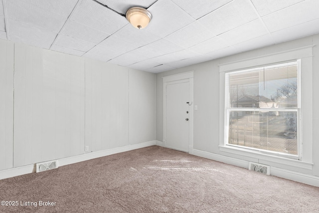 unfurnished room with carpet flooring and visible vents