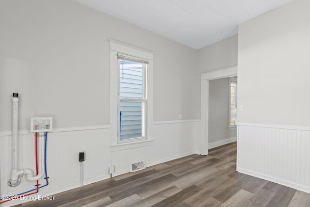 unfurnished room with wainscoting, wood finished floors, and visible vents