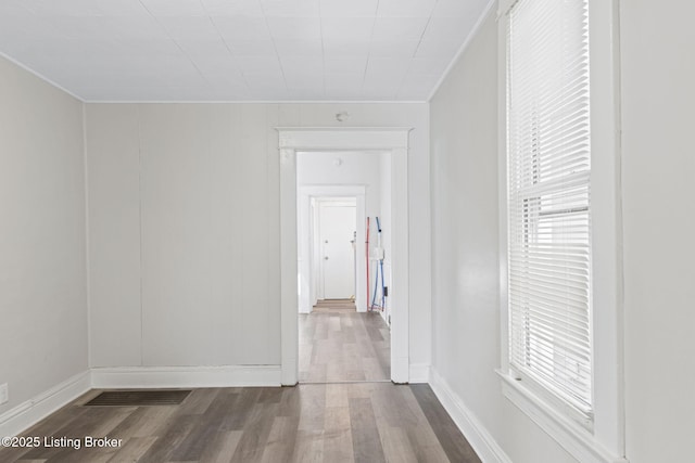 interior space featuring dark wood-style floors, a wealth of natural light, visible vents, and crown molding