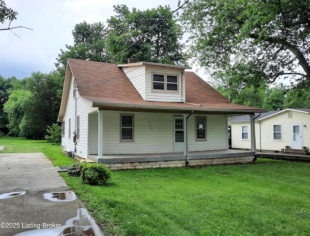 view of front facade with covered porch, a shingled roof, and a front yard