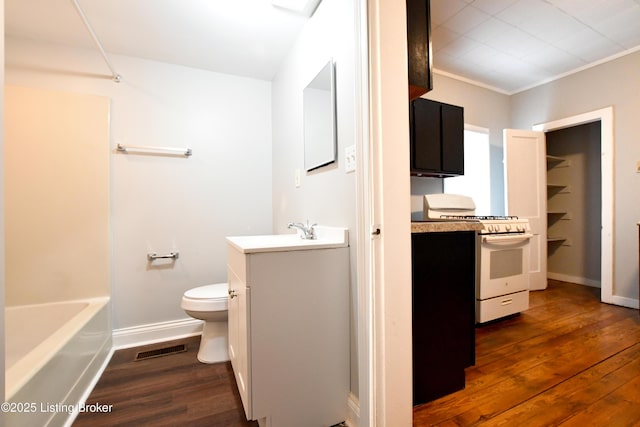 full bathroom featuring visible vents, toilet, vanity, wood finished floors, and baseboards