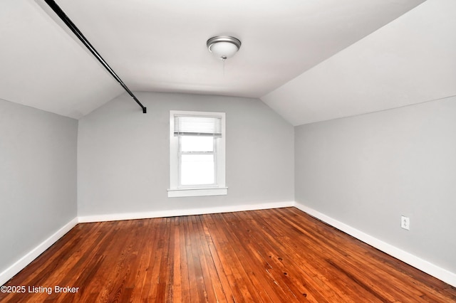 bonus room featuring lofted ceiling, baseboards, and hardwood / wood-style floors