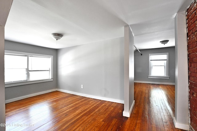 unfurnished room with baseboards and hardwood / wood-style floors