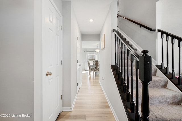 corridor featuring light wood-style floors, recessed lighting, stairway, and baseboards