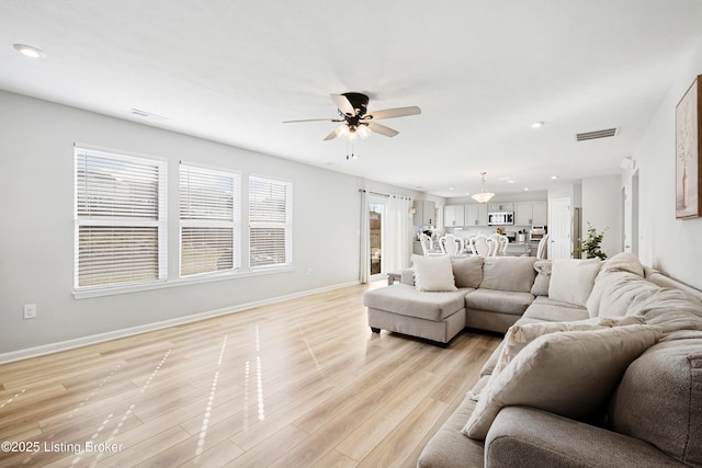 living area featuring light wood finished floors, recessed lighting, visible vents, a ceiling fan, and baseboards