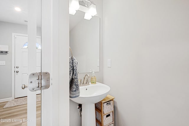 bathroom with wood finished floors and baseboards