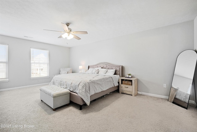 carpeted bedroom with visible vents, baseboards, and a ceiling fan