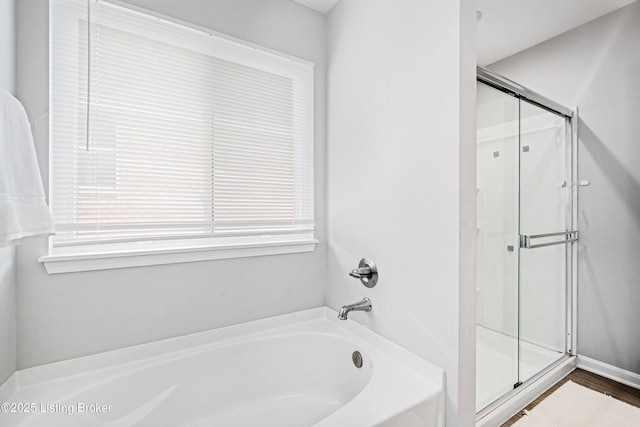 bathroom with a shower stall and a bath