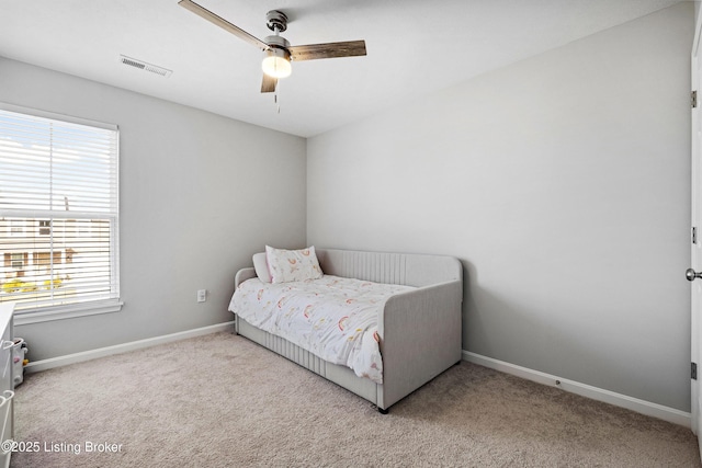 carpeted bedroom featuring ceiling fan, visible vents, and baseboards