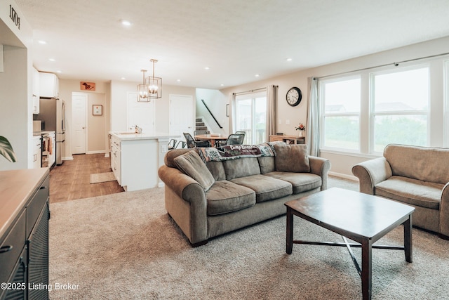 living room with recessed lighting, visible vents, light wood-style floors, a chandelier, and stairs