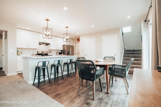 dining area featuring stairs, baseboards, wood finished floors, and recessed lighting