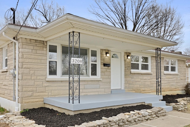 entrance to property featuring stone siding and covered porch