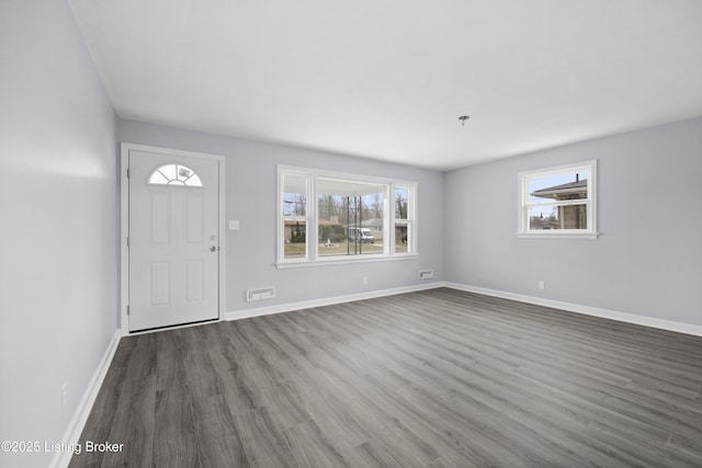 entrance foyer with plenty of natural light, visible vents, baseboards, and dark wood-style flooring